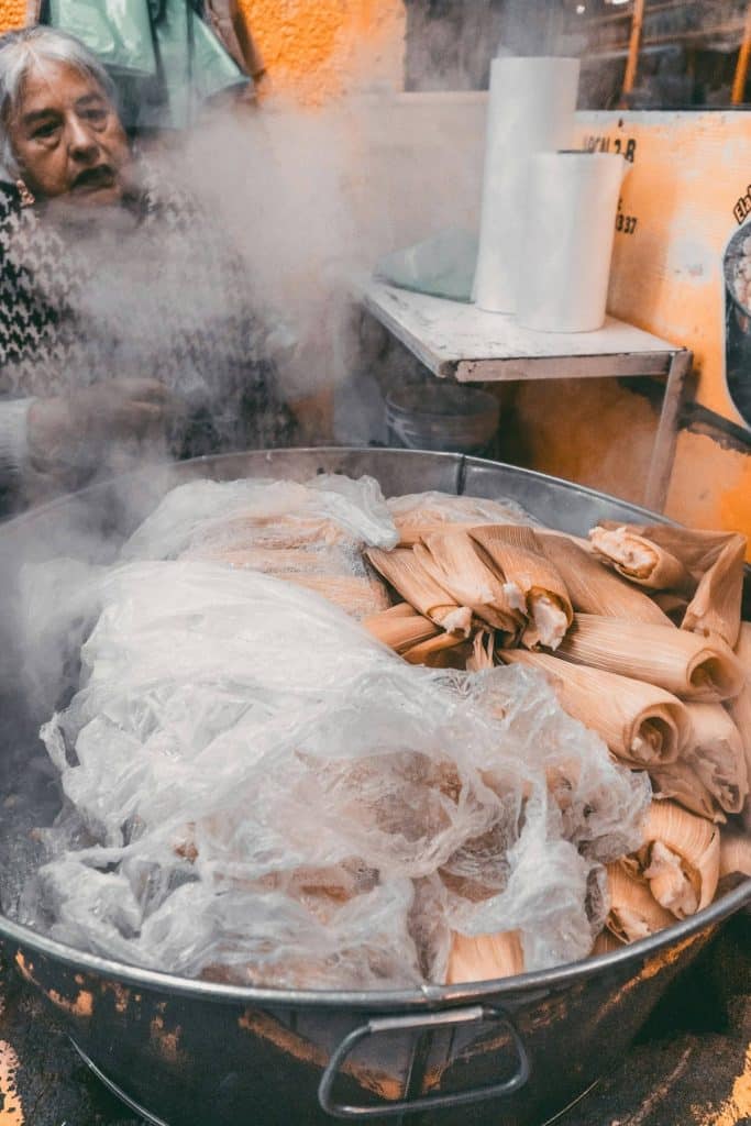 a pot of tamales with steam coming off of them